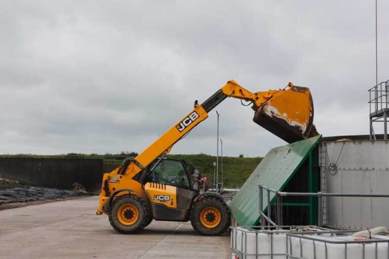 JCB telehandler loading agricultural waste into sorting storage